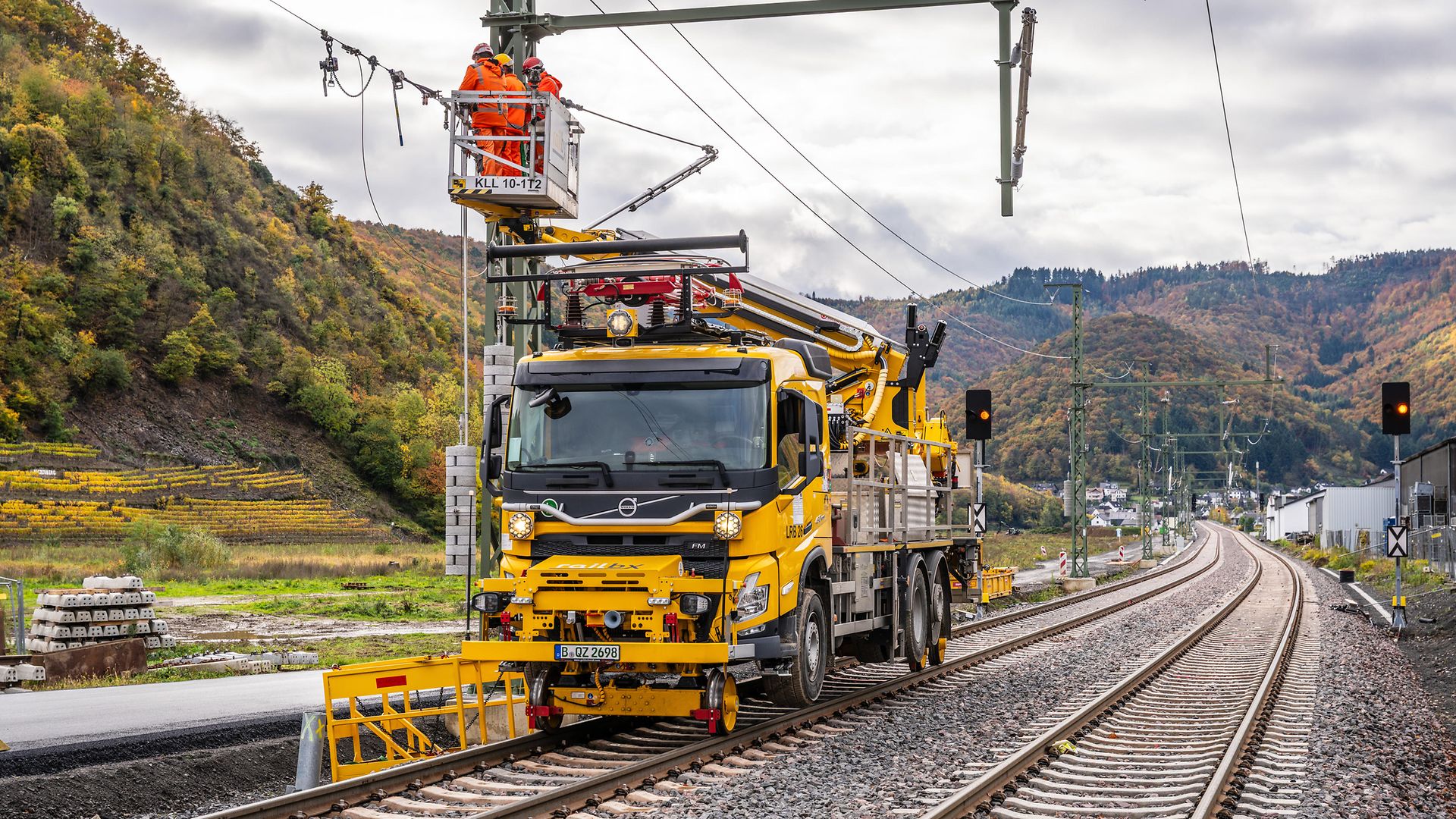 Bauarbeiter stehen in einem Korb auf einer Drehleiter bei Oberleitungsarbeiten an der Ahrtalbahn