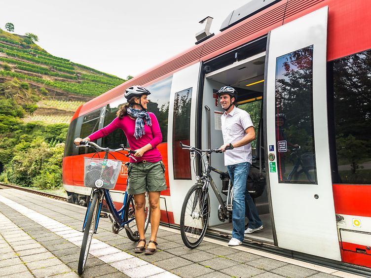 Fahrradfahrer beim Ausstieg aus dem Zug am Gleis