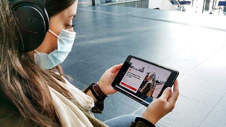 Frau mit Tablet am Bahnhof
