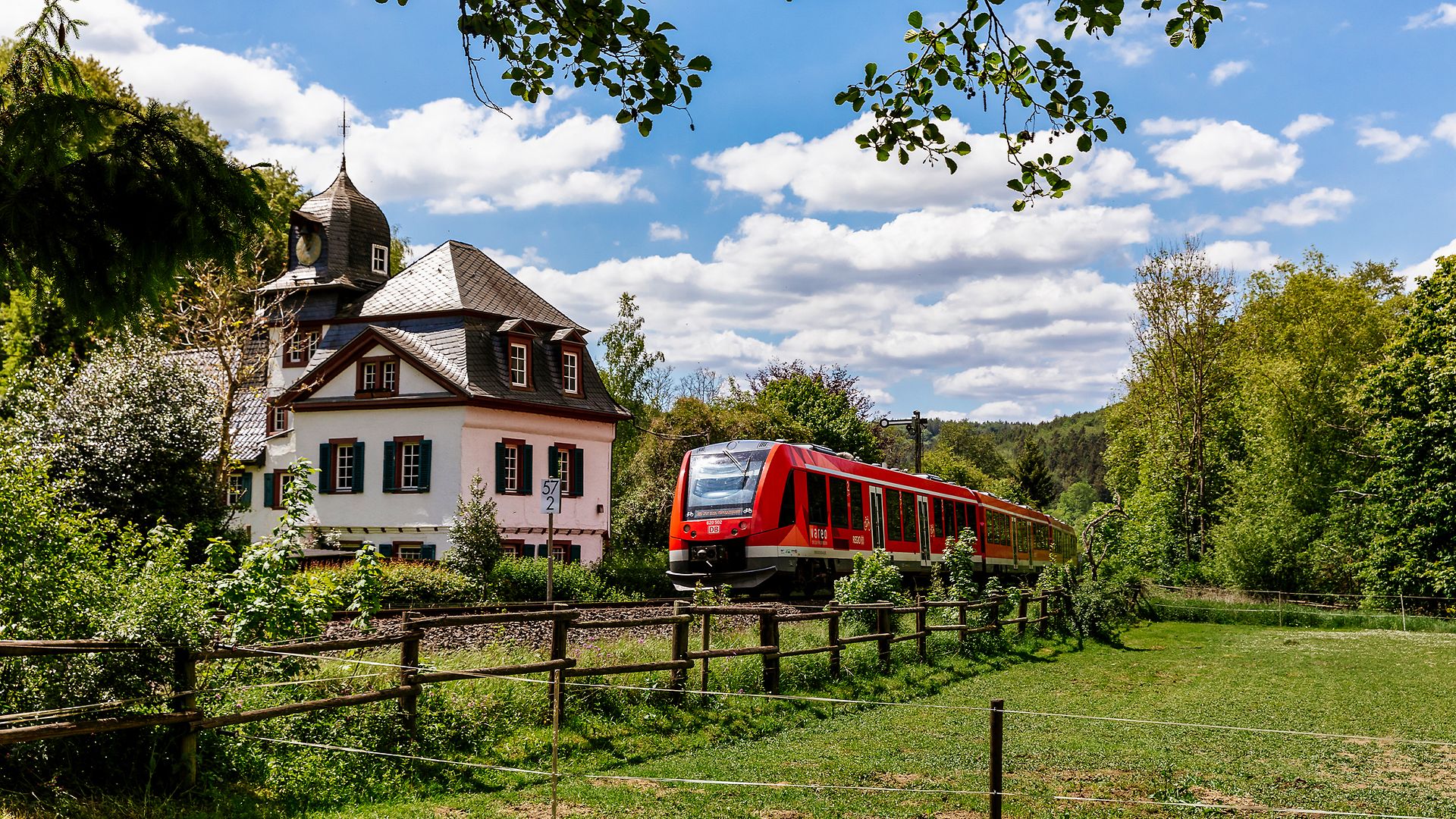 Ein vareo-Zug (LINT) fährt durch die Landschaft. Im Hintergrund eine kleine Kirche.